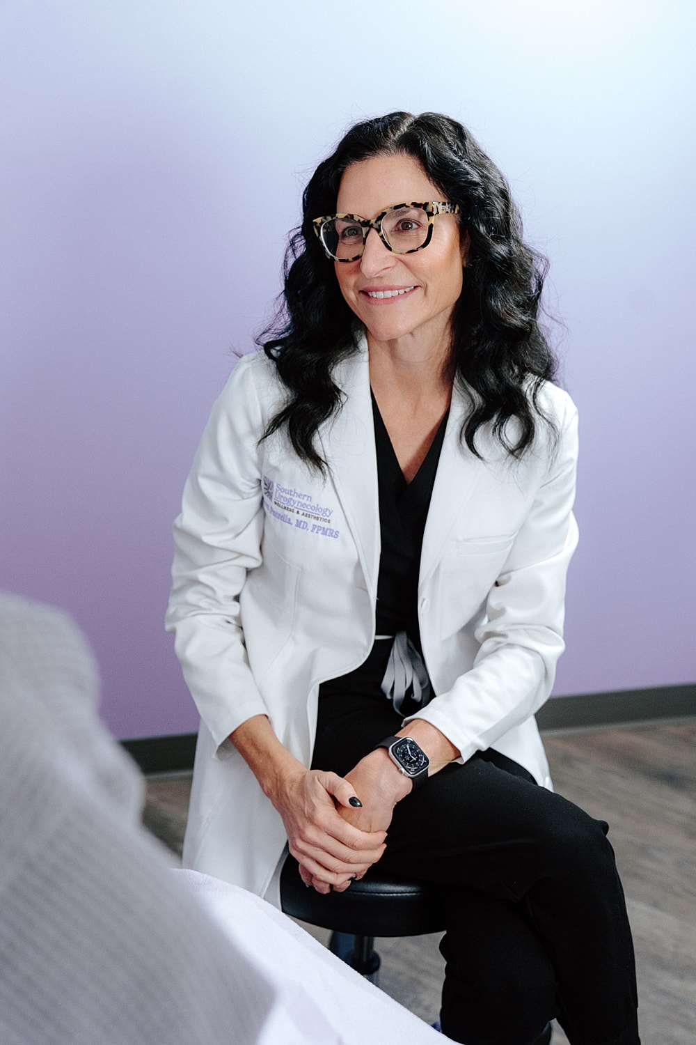 Doctor in white coat smiling at patient.
