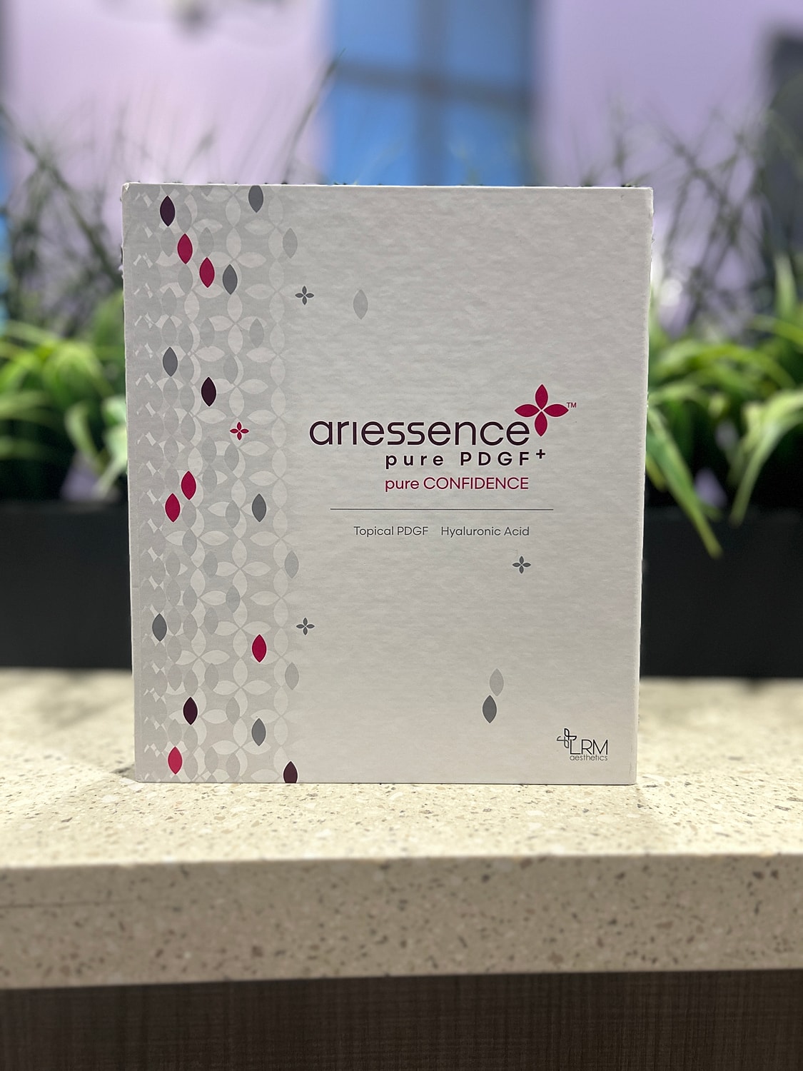 Ariessence PDGF box on countertop with greenery.