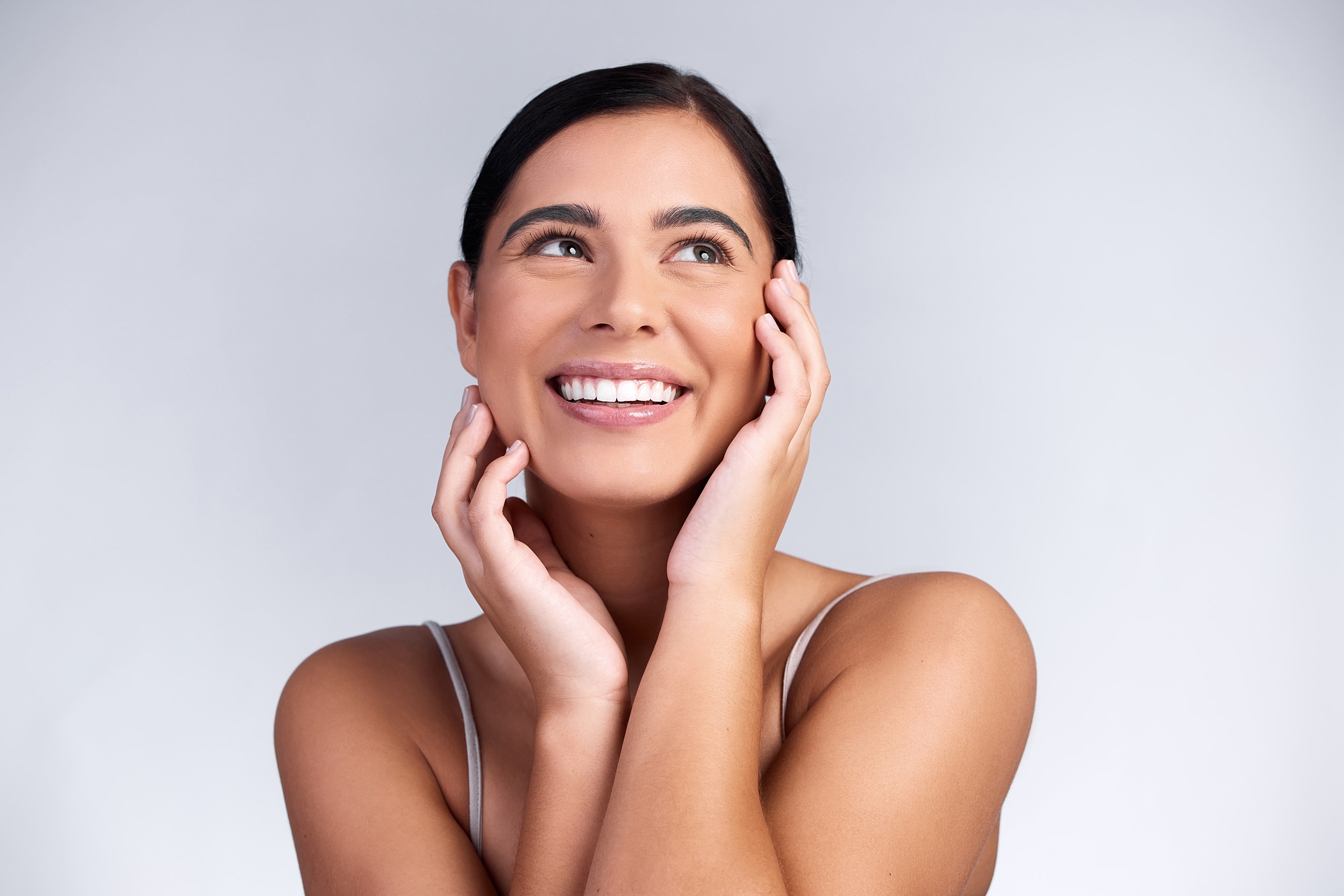 Smiling West Columbia ThermiSmooth woman with hands on her face.